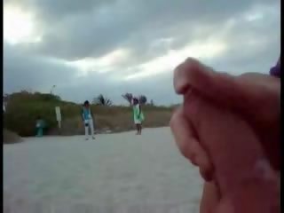 Amerikaans toerist aftrekken op de strand terwijl vrouw passing door video-